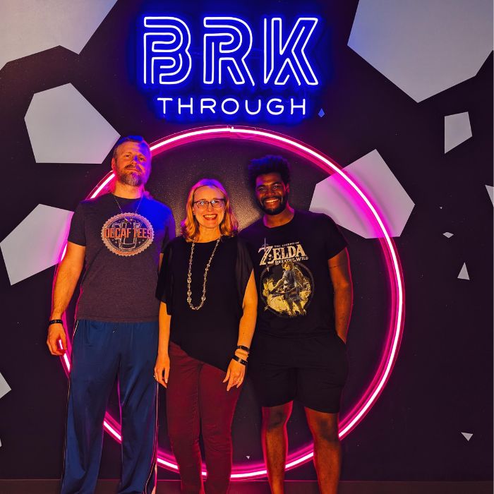 Lindsay and her husband and a friend pose in front of the BRKthrough sign