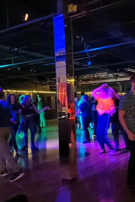 West Coast Swing Dancers with Party lights and a mirrored column on a wood dance floor