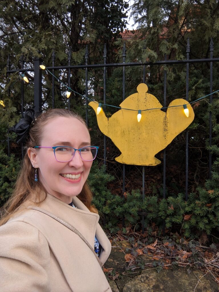 Lindsay next to the yellow tea pot sign