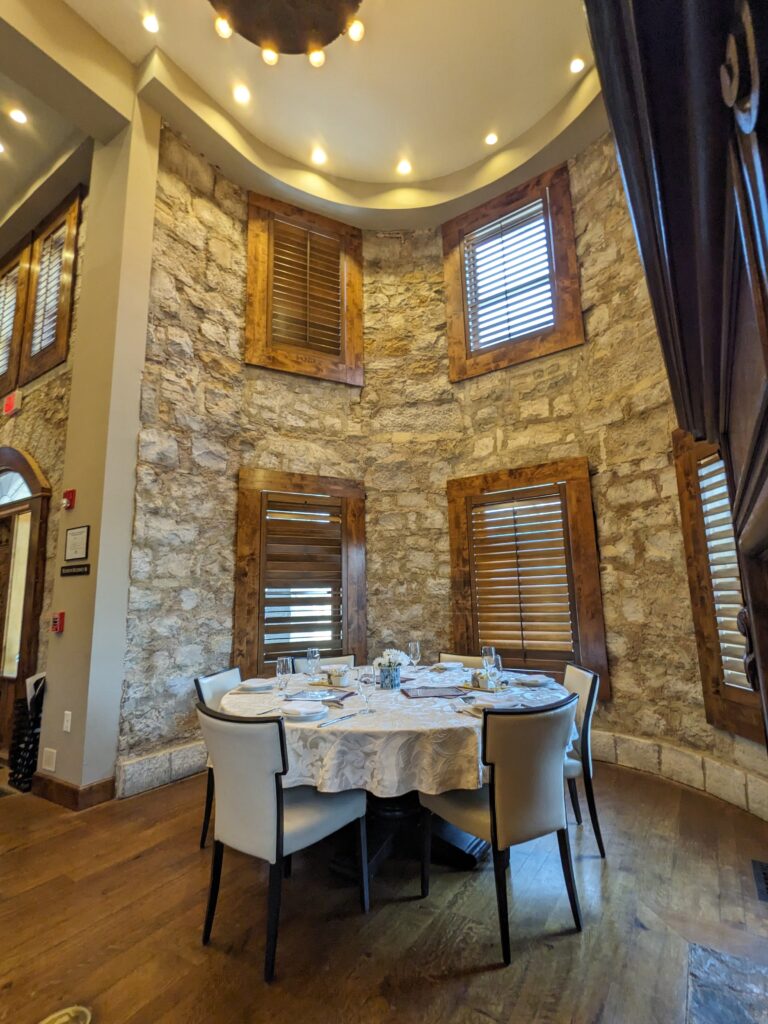 Inside of The Castle with table set for tea with tall stone round wall behind