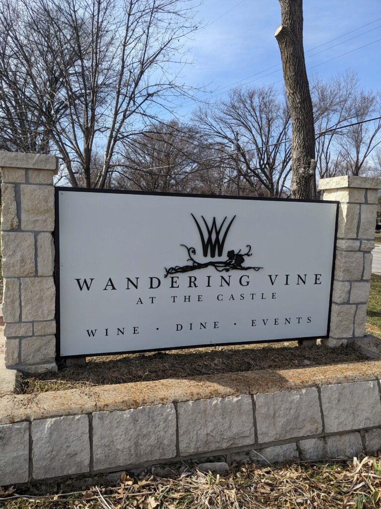 Wandering Vine at the Castle horizontal sign with W in stone base