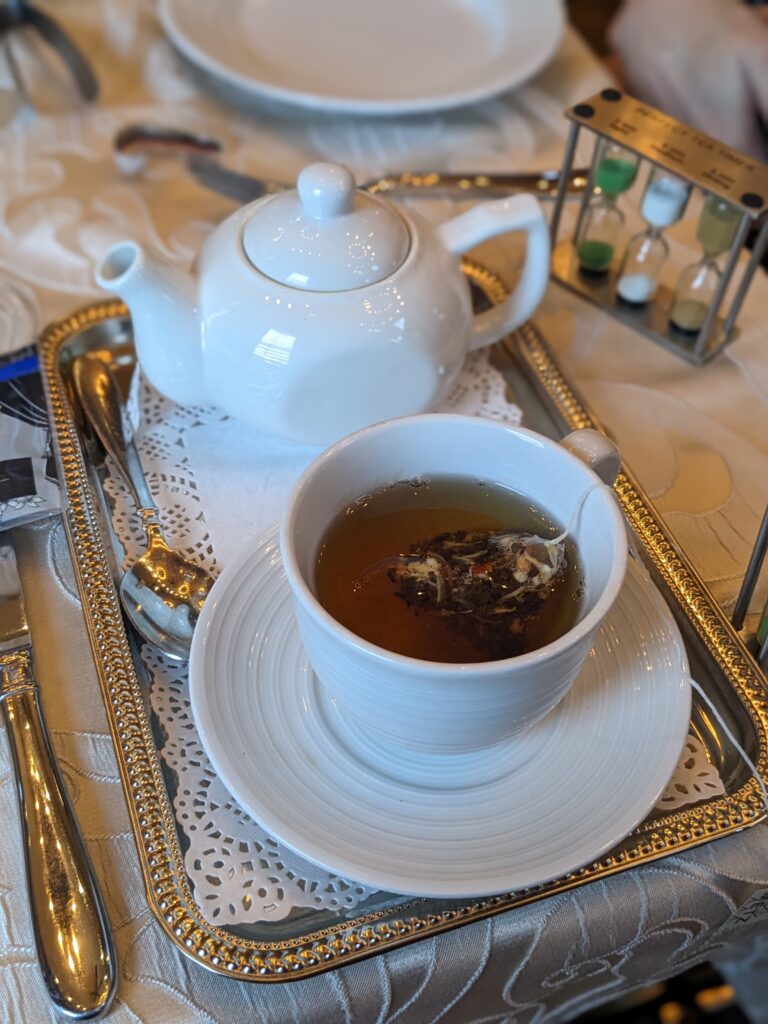 Individual tea serving with small pot and cup of tea with tea bag