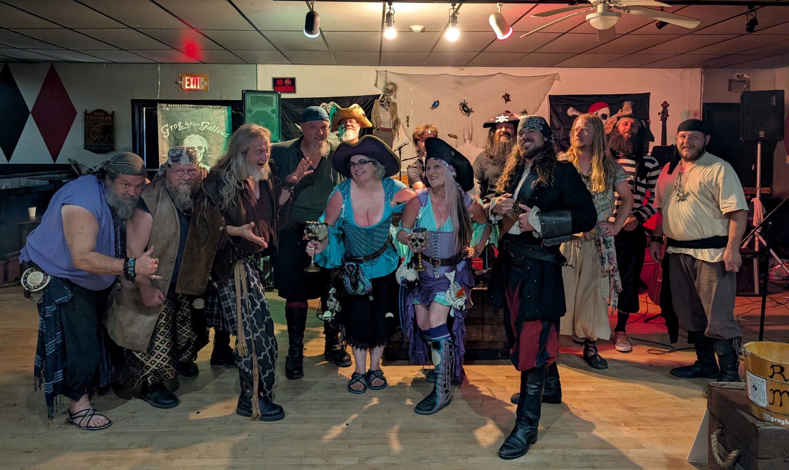 A group of Renaissance pirate musical performers pose together in the Under the Deck Bawdy pirate bar.