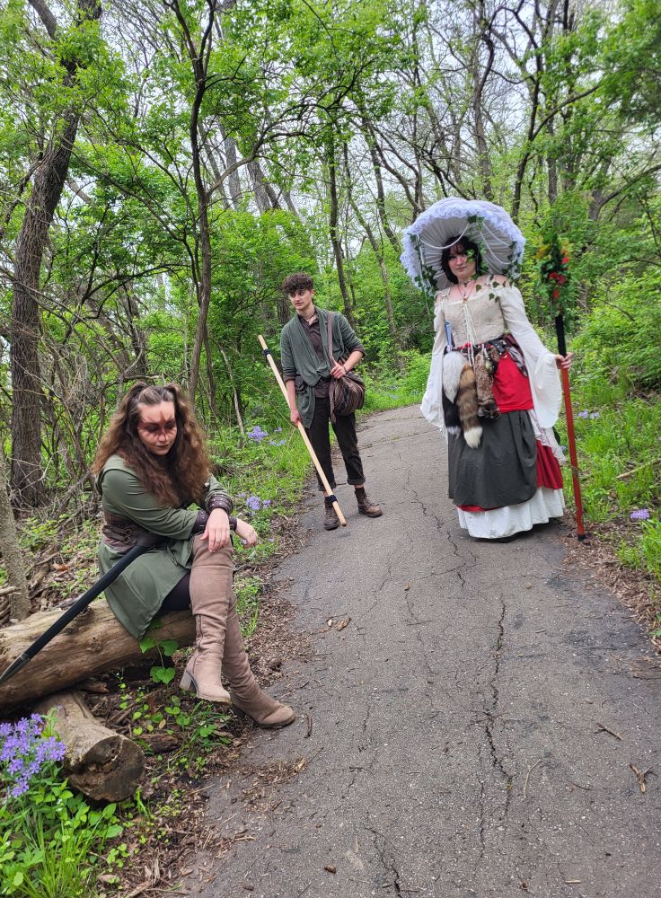 3 costumed characters on a path dressed for a Renaissance Festival