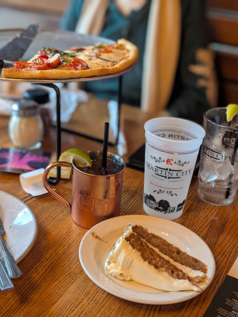 Slice of carrot cake, mule cocktail, and pizza