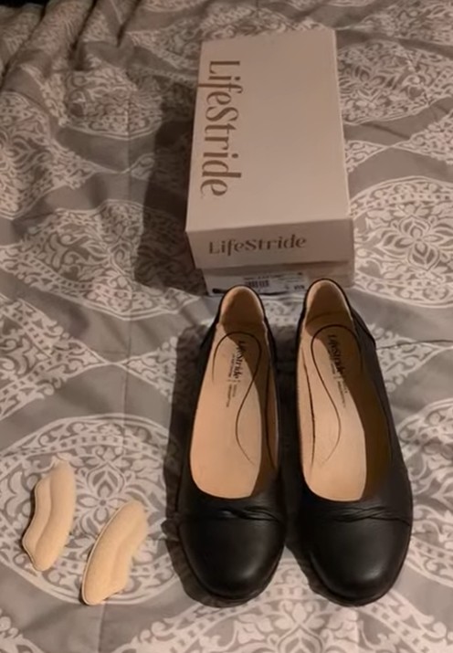 black shoes next to heel cushions and a shoe box