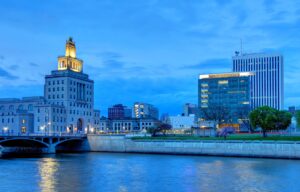 Cedar Rapids, Iowa blue evening sky with skyline with medium skyscrapers one illuminated at the top